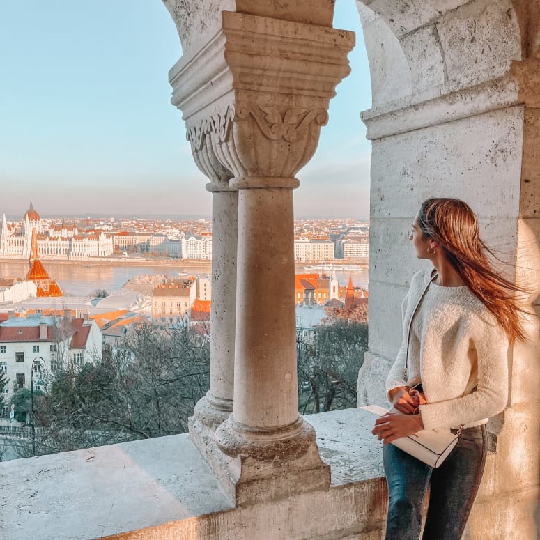 A student looking out towards a view of Budapest.